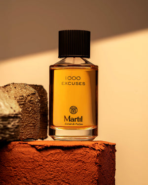 Flacon du parfum 1000 Excuses de Martil, extrait de parfum photographié dans une ambiance chaude et lumineuse