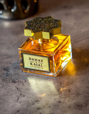 Bouteille de Kajal Dahab posée sur surface brute, lumière chaleureuse révélant la teinte ambrée